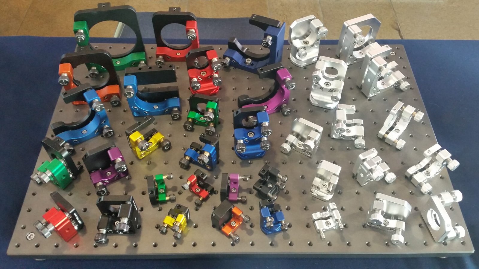 Third-party reference photo of optical mirror mounts with mounting bores and adjustment hardware